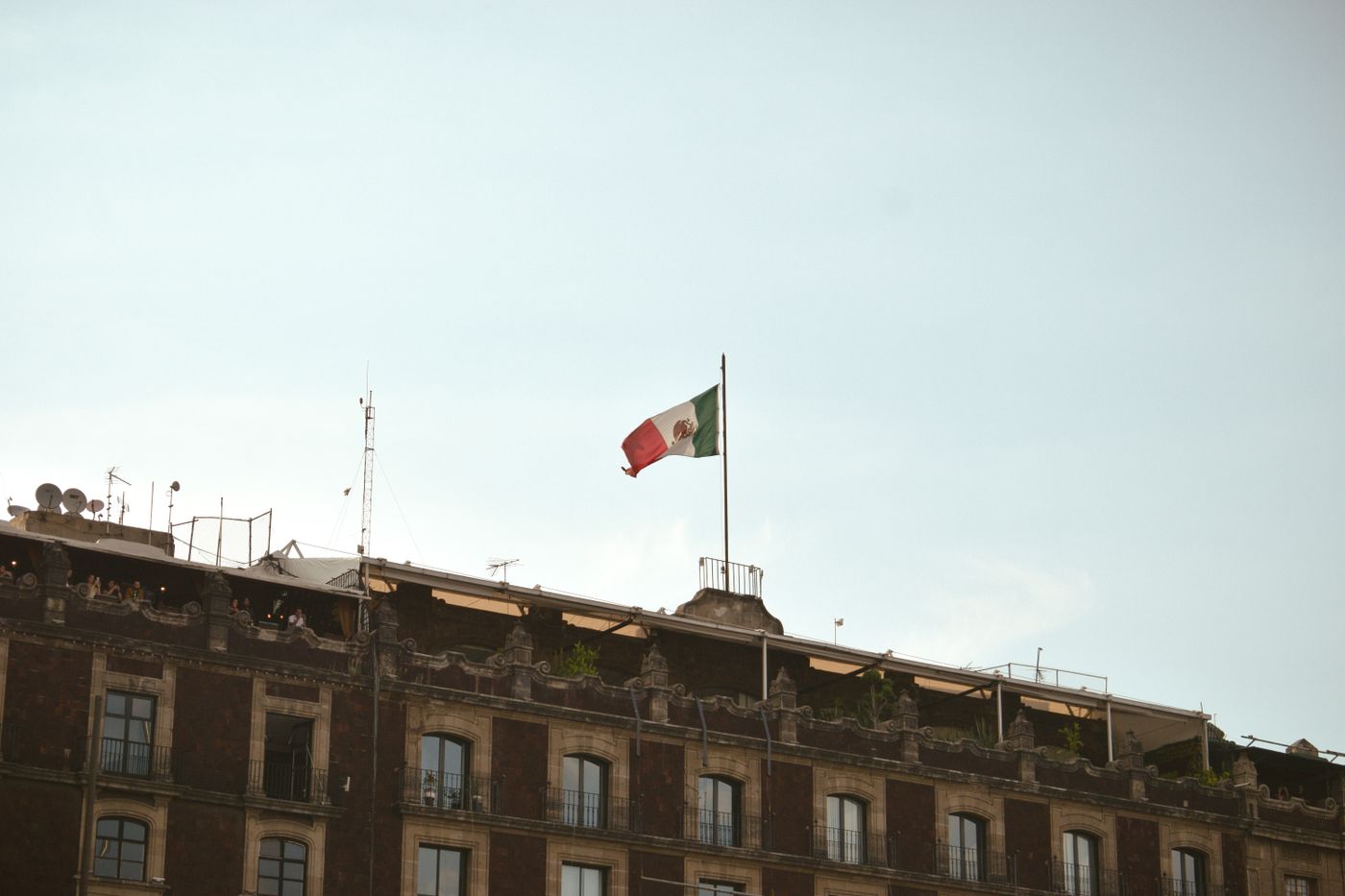 Mexican flag flying above a historic building